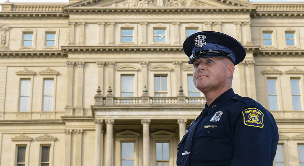 State Properties Security Officer standing in front of Michigan State Capitol building.