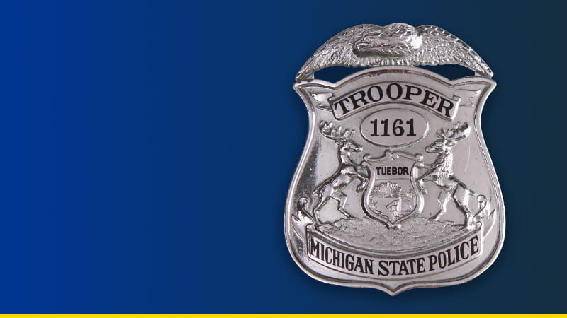 Michigan State Police trooper badge on dark blue background. 
