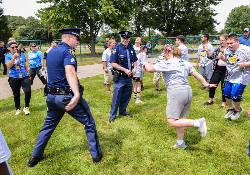 Group of kids and police officers dancing outside