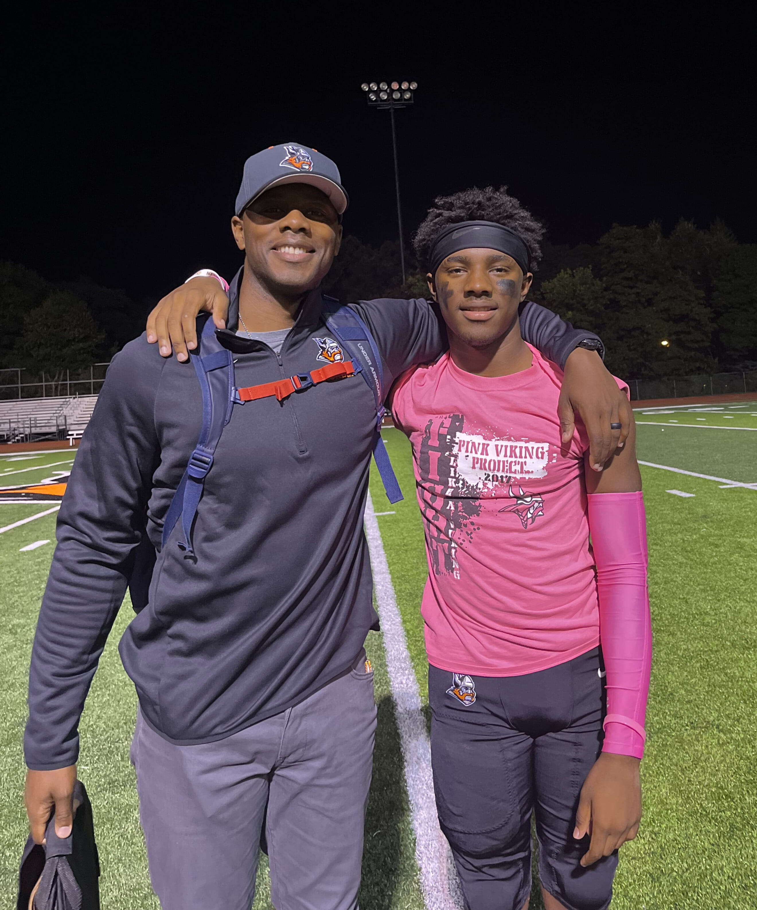 Photo of Lieutenant Tedric Gibbs and son on sidelines of football field