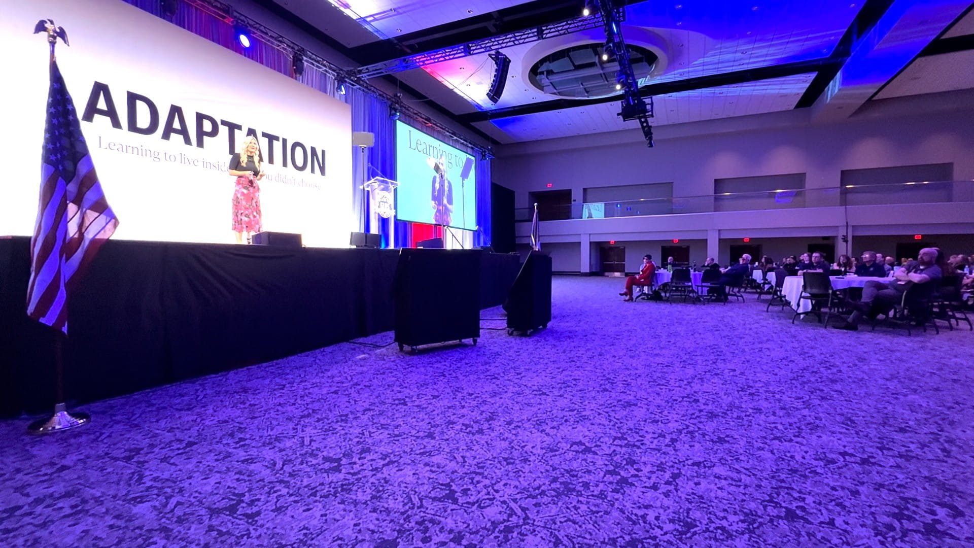 Woman speaking on stage in a dimly lit room during the 2026 Great Lakes Homeland Security Conference