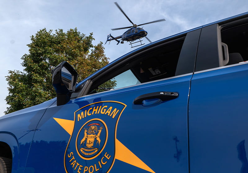 Close-up of MSP patrol car with helicopter overhead. 