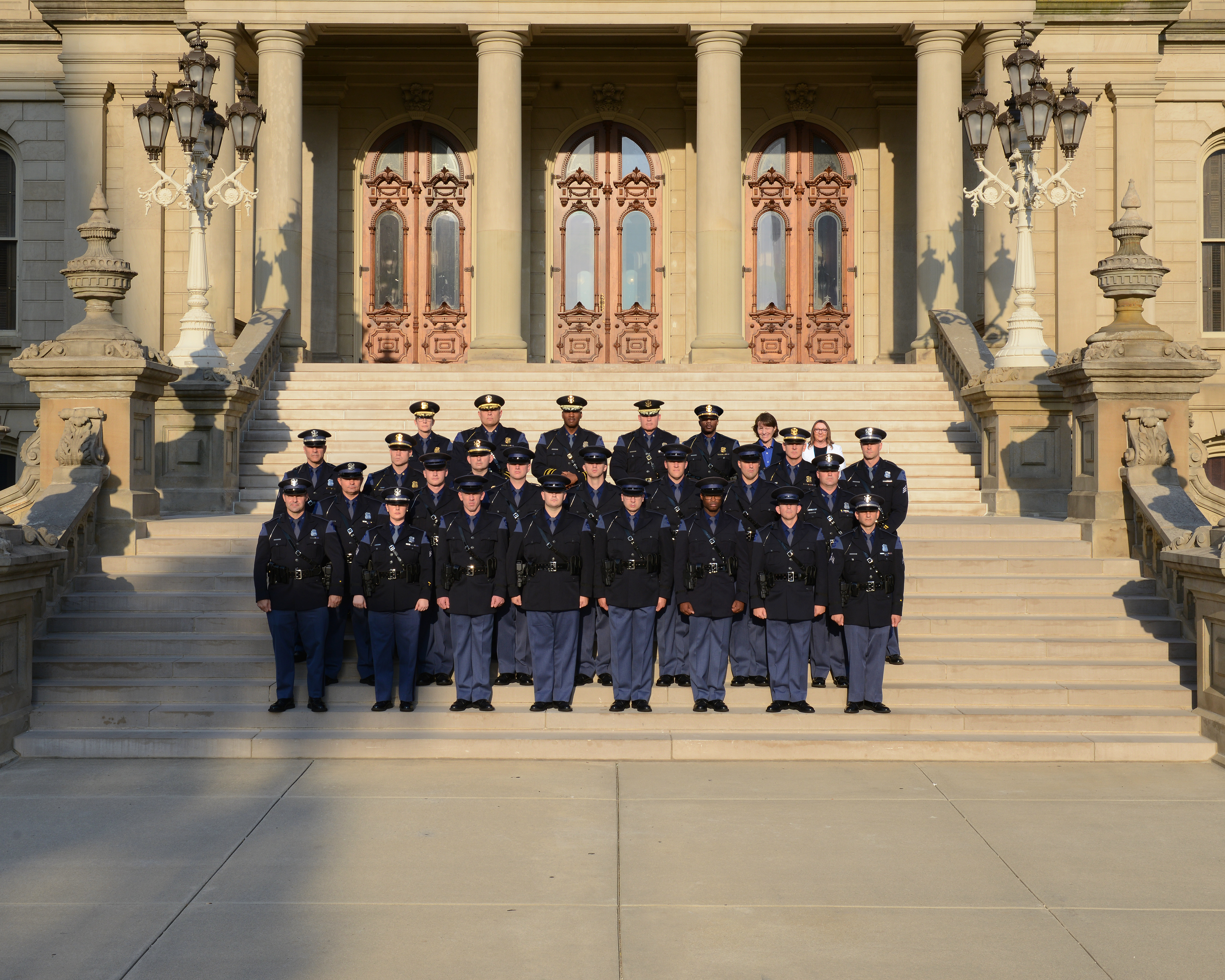 Members of the 151st Trooper Recruit School class standing in uniform, outside, on the Capitol Steps