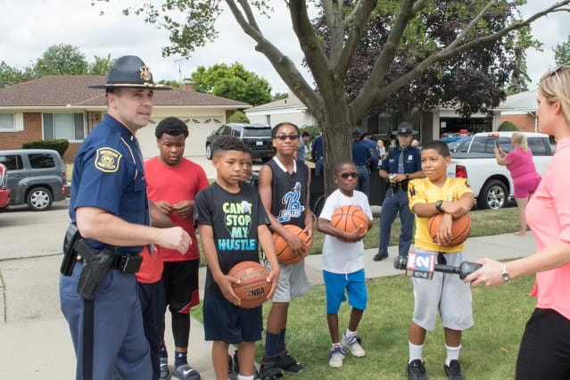 Michigan State Police Troopers playing basketball with children