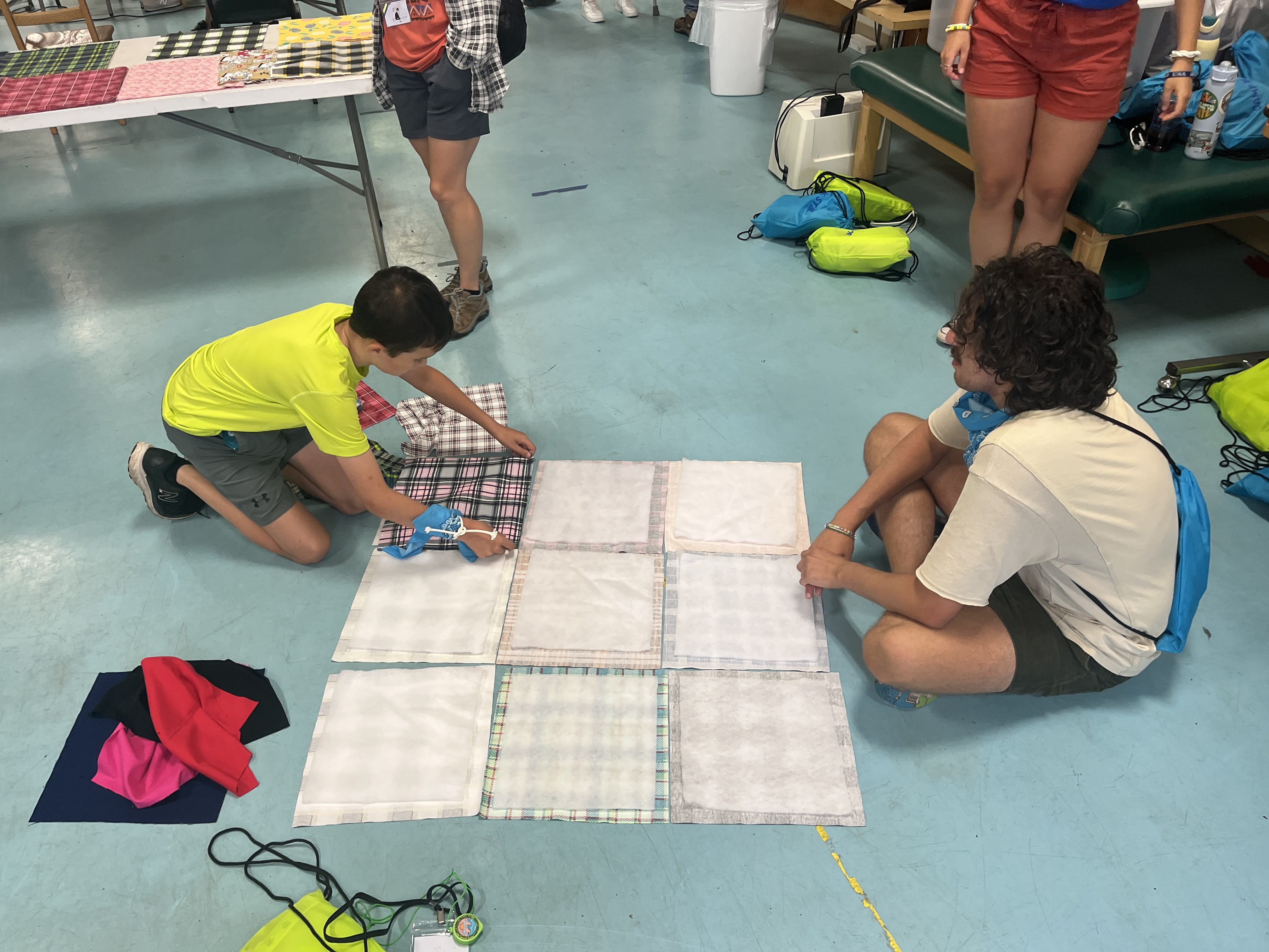 Camper crafting a memory quilt made with their loved one's clothing