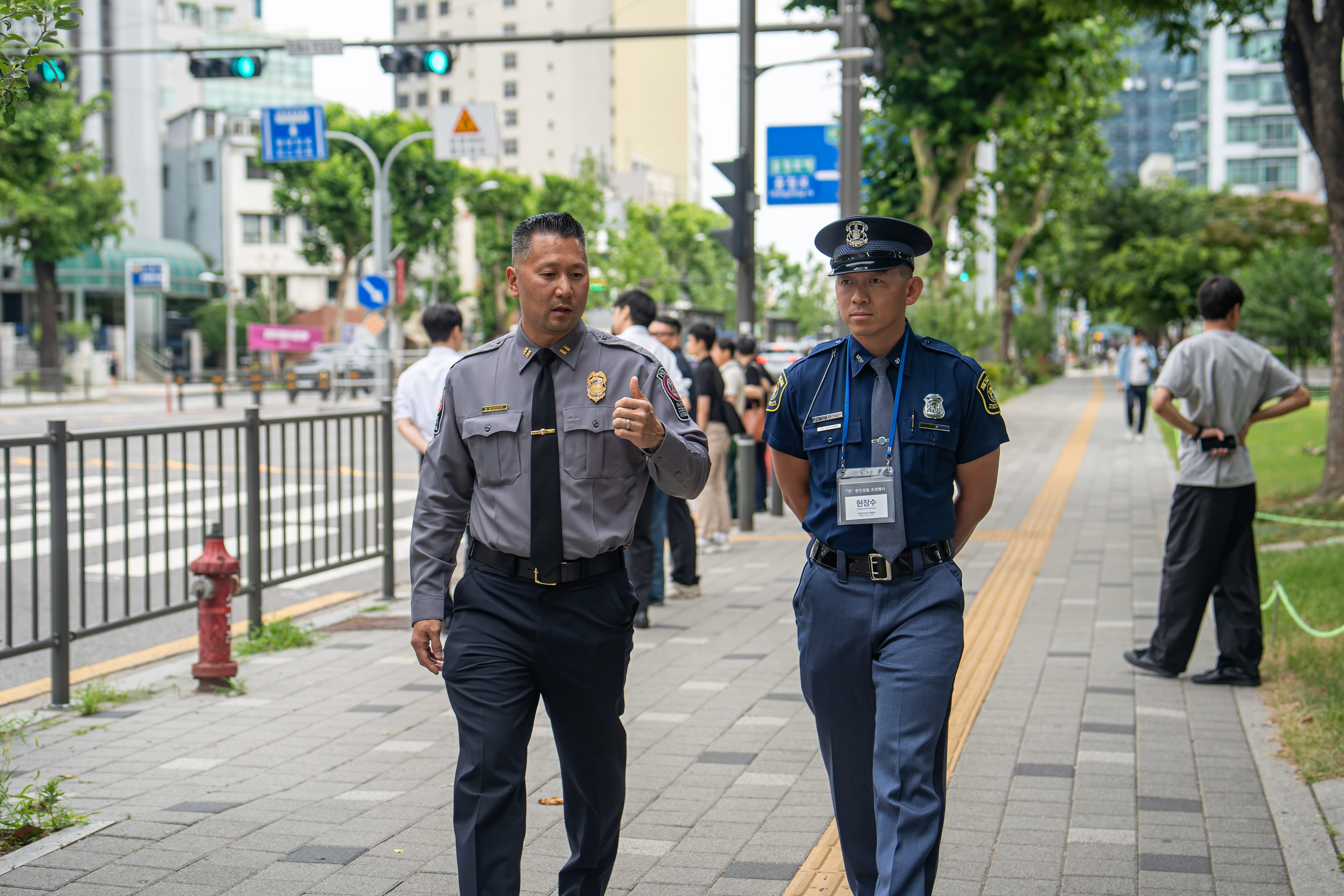 Trooper Tom Kinnunen in uniform walking down a sidewalk with another program participant