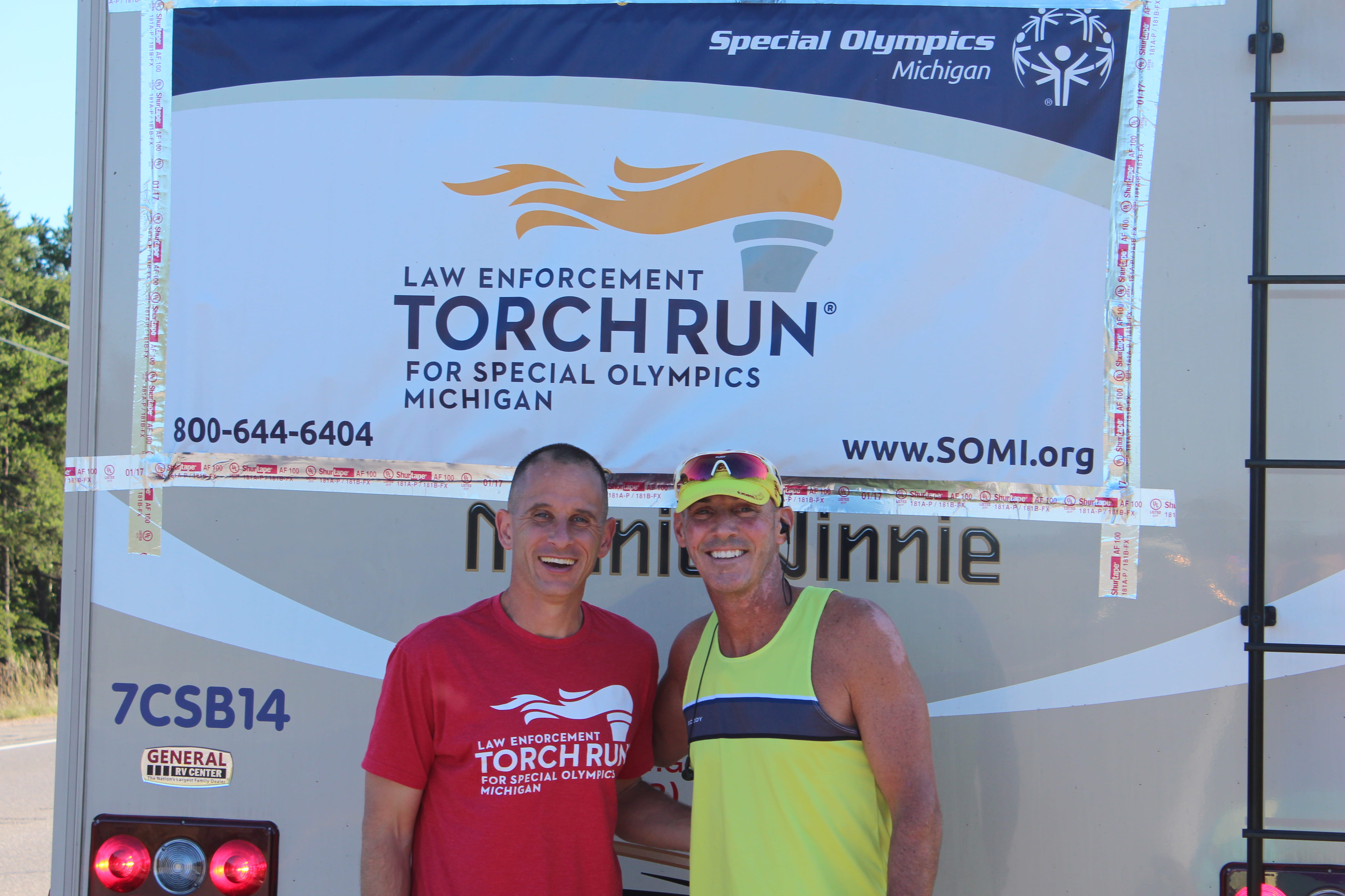 Photo of Captain Sweeney and another MSP member standing behind a vehicle after running
