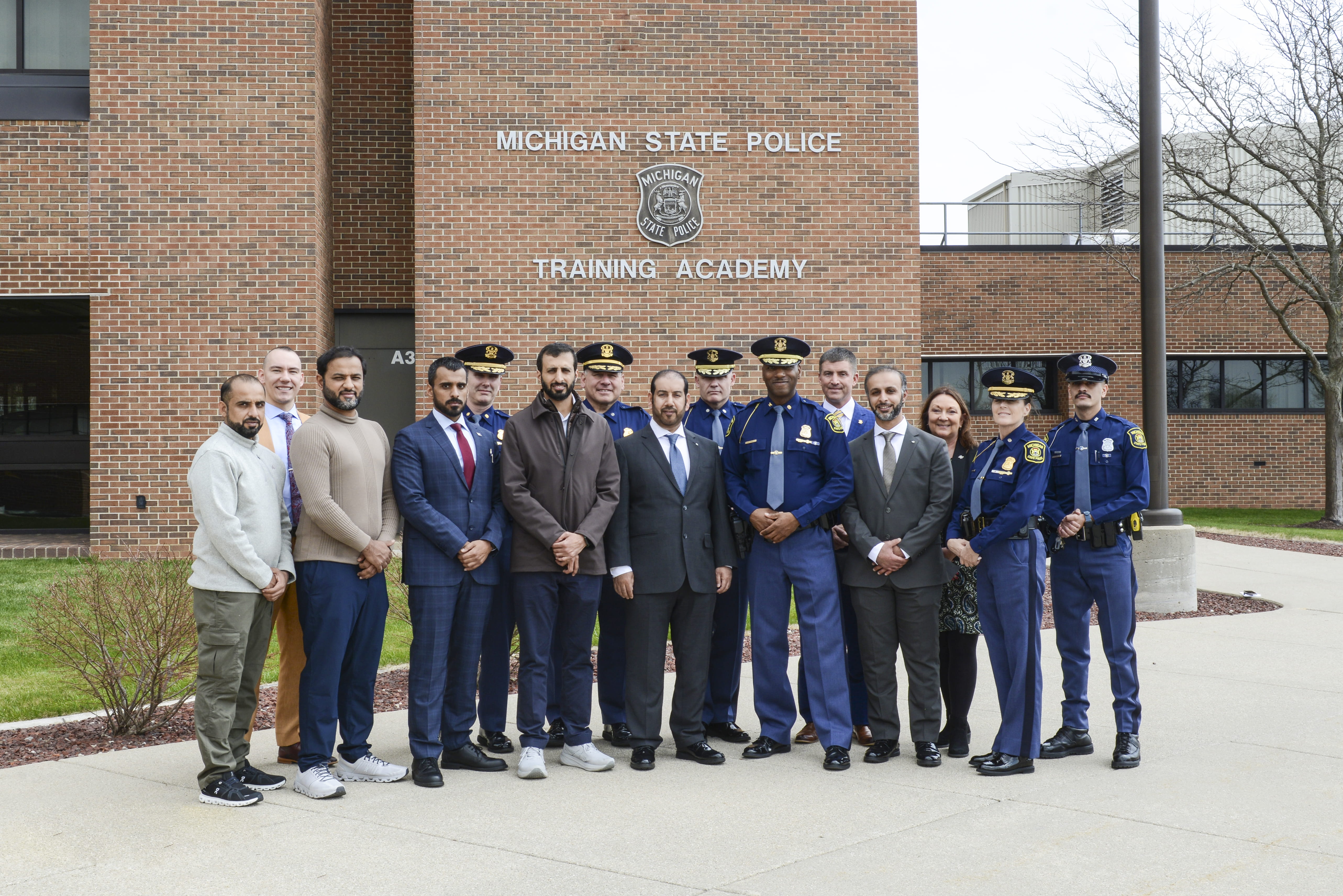 MSP leaders and member of United Arab Emirates law enforcement standing outside in front of the MSP Training Academy