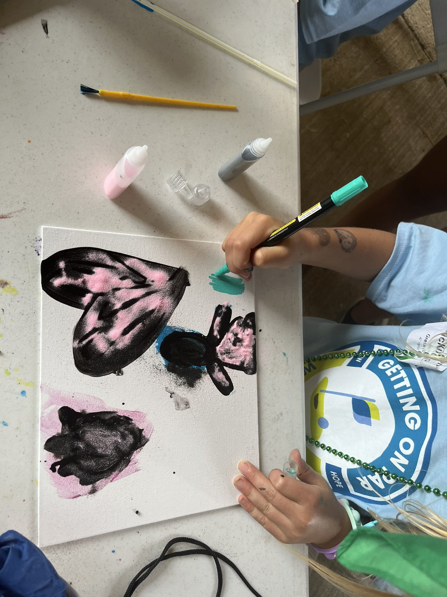 Child painting a heart on a canvas 