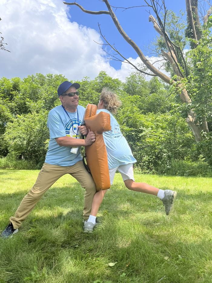 Officer playing football with a camper