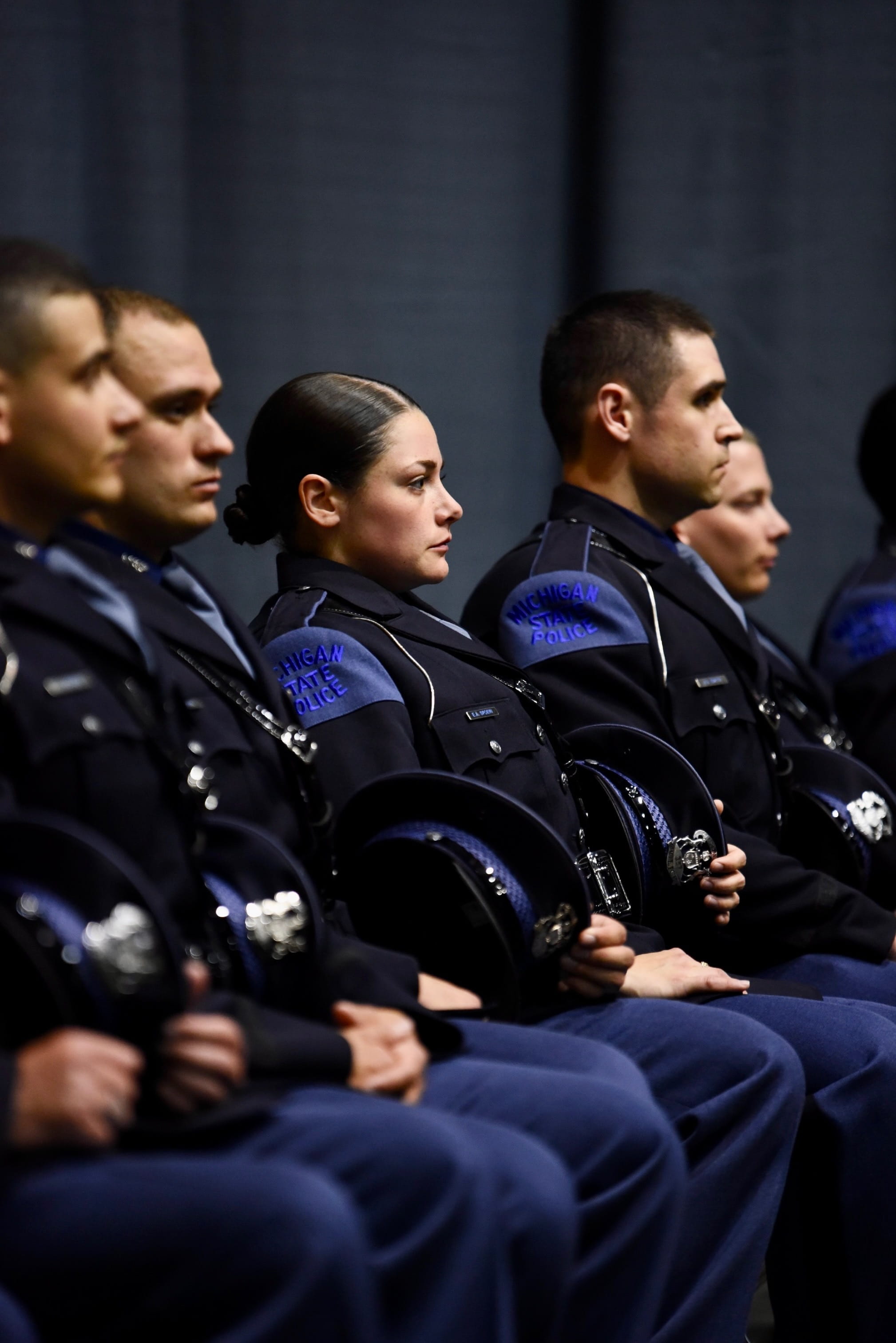 Photo of Tpr. Emily Spoeri sitting with fellow troopers during Trooper Recruit School graduation
