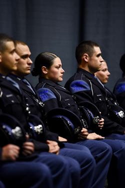 Photo of Tpr. Emily Spoeri sitting with fellow troopers during Trooper Recruit School graduation