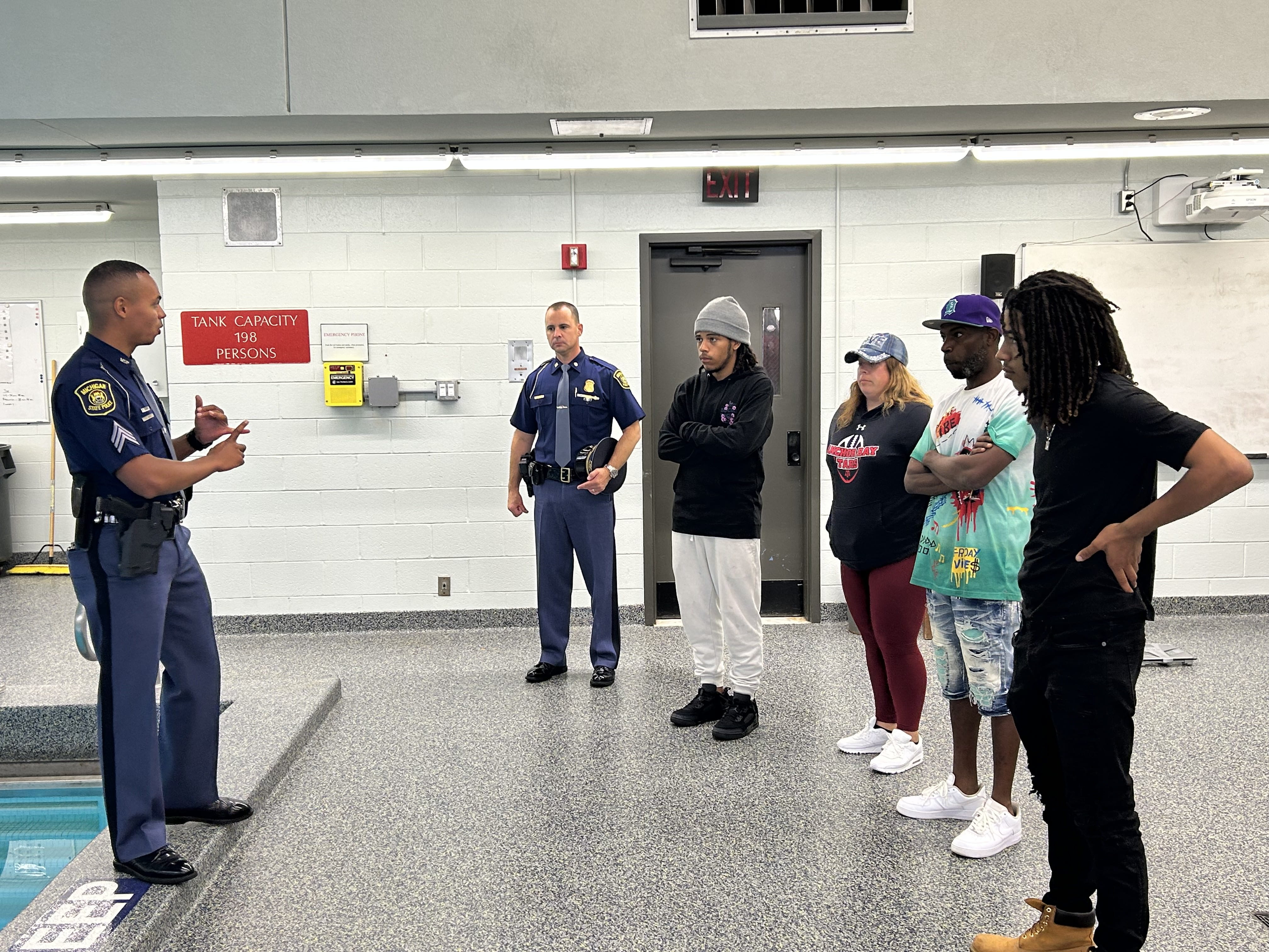 Sgt. DiJon Ware and Capt. Greg Morenko touring the pool area at the Training Academy with the Horton family