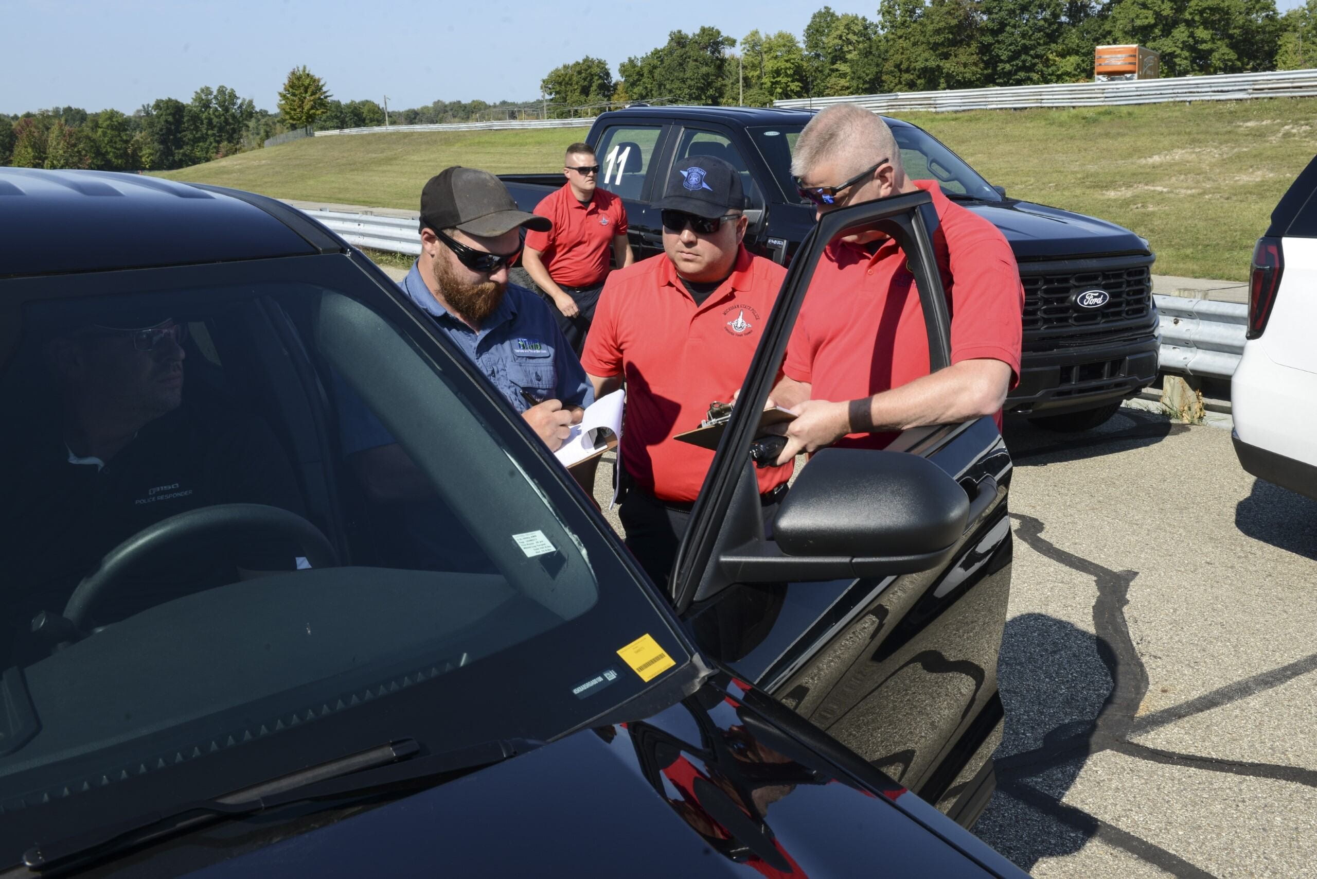 Test team standing outside next to vehicle with the door open