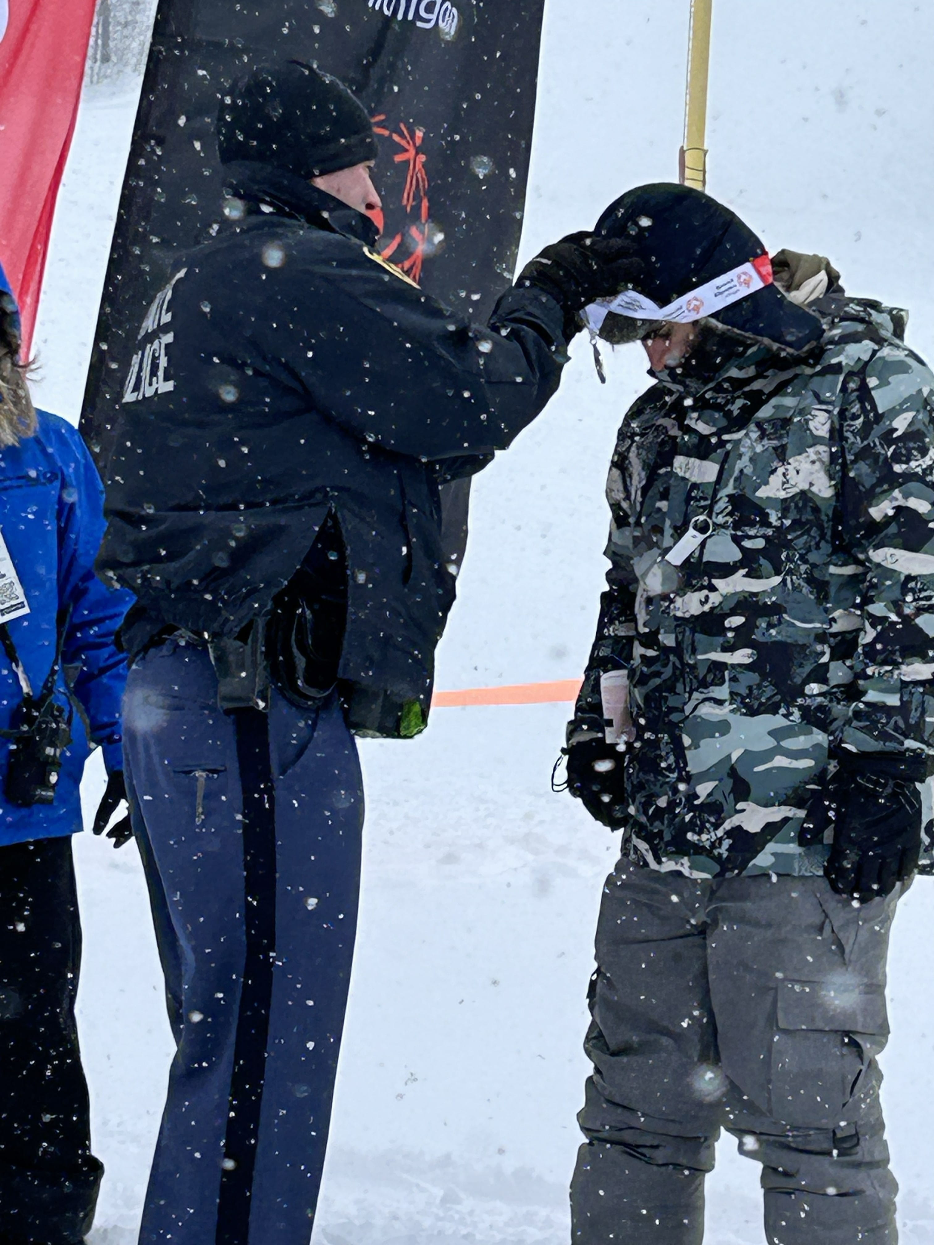 Trooper putting medal on athlete
