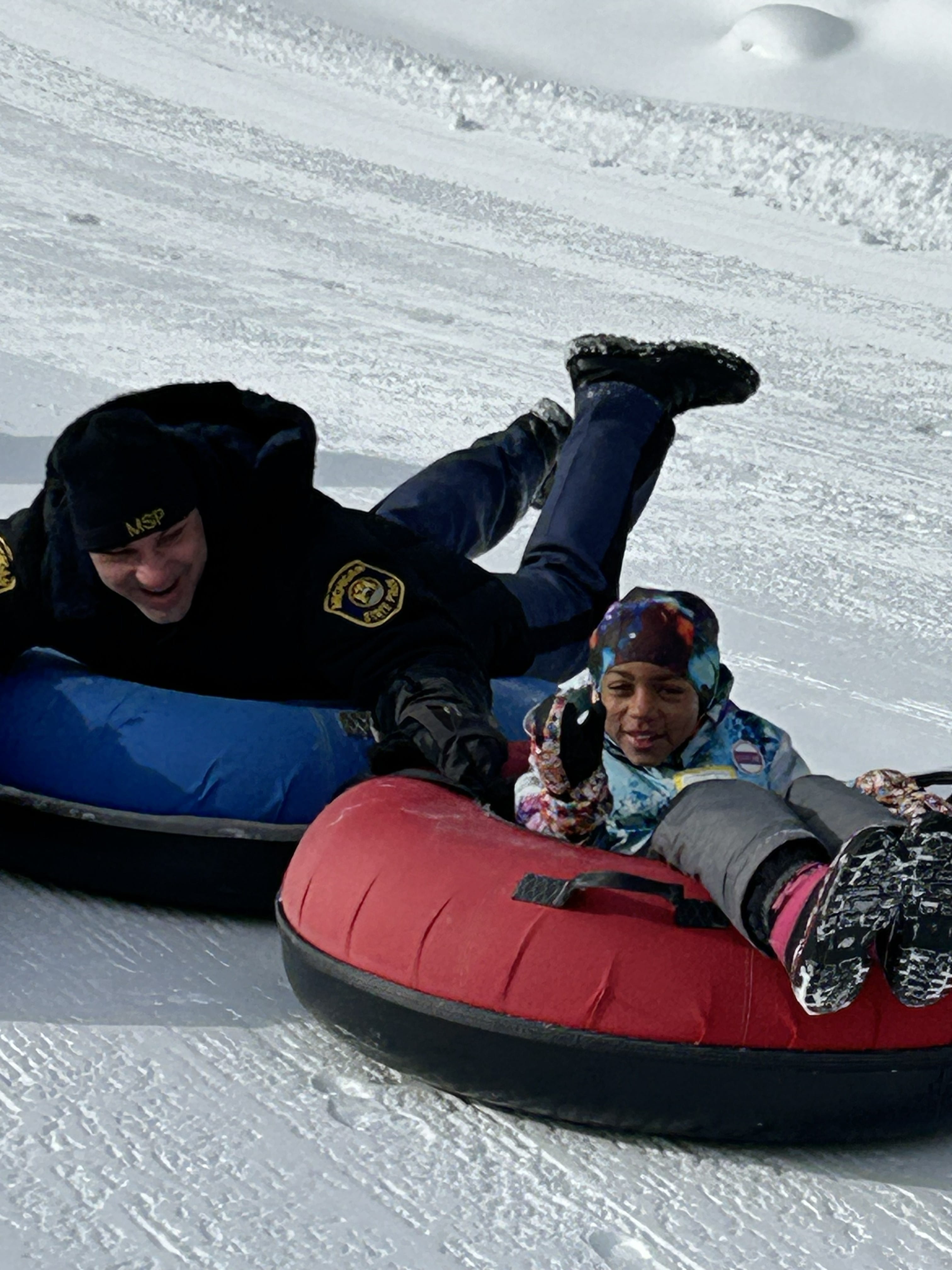 Trooper tubing in the snow with athlete