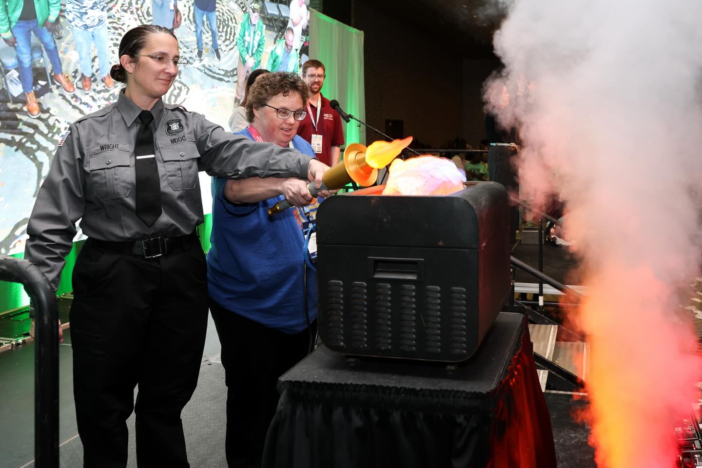 Officer and athlete lighting the flame at State Winter Games opening ceremony