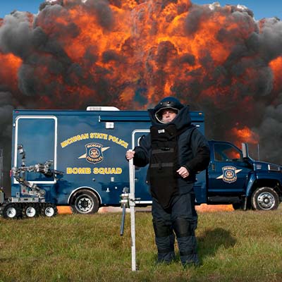 picture of bomb squad member standing in front of explosion
