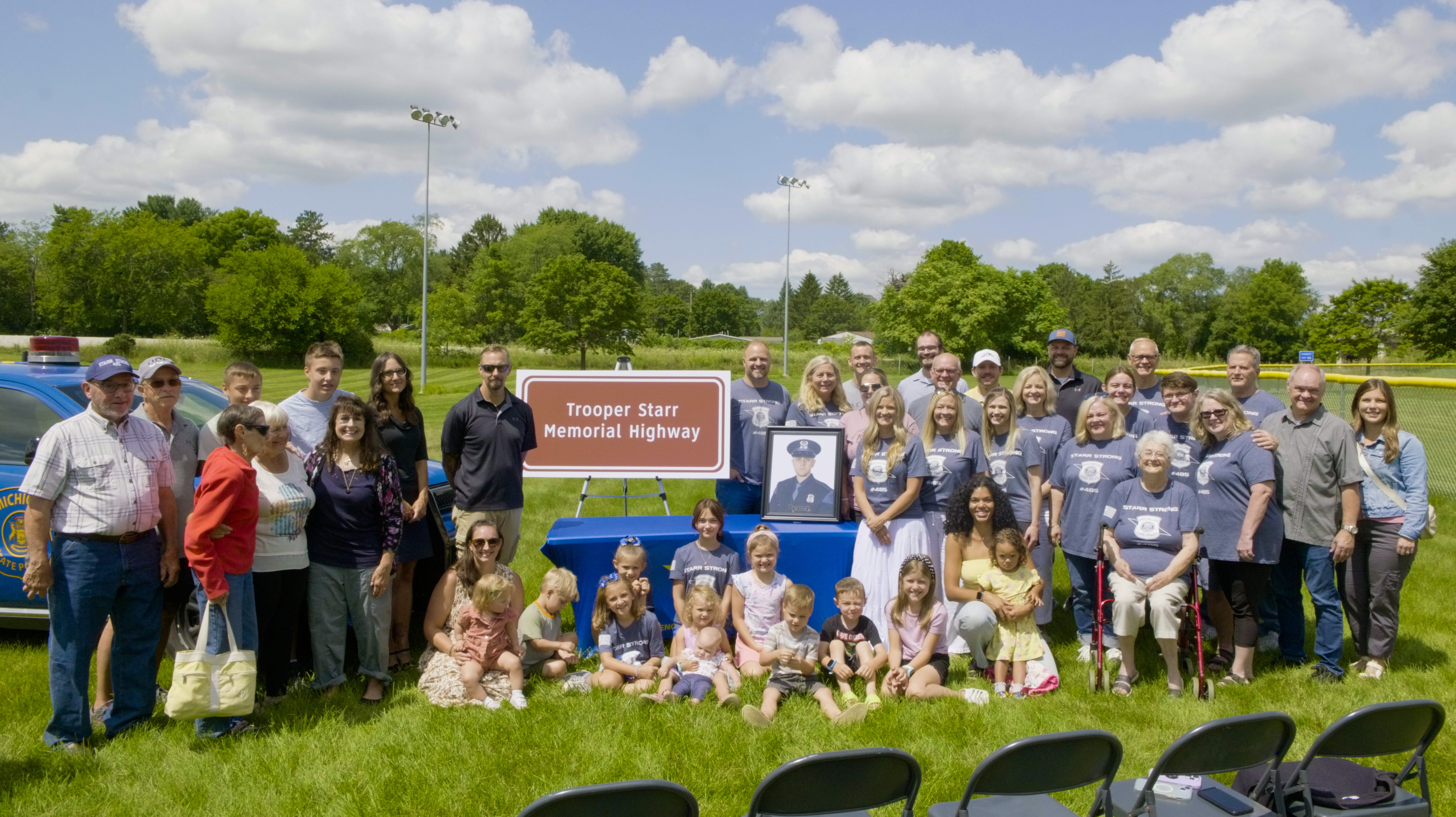 Relatives of fallen Lakeview Post Tpr. Caleb H. Starr gathers for a photo at Hayes Park alongside US-127 in Mason for a highway memorial dedication ceremony, July 19, 2024