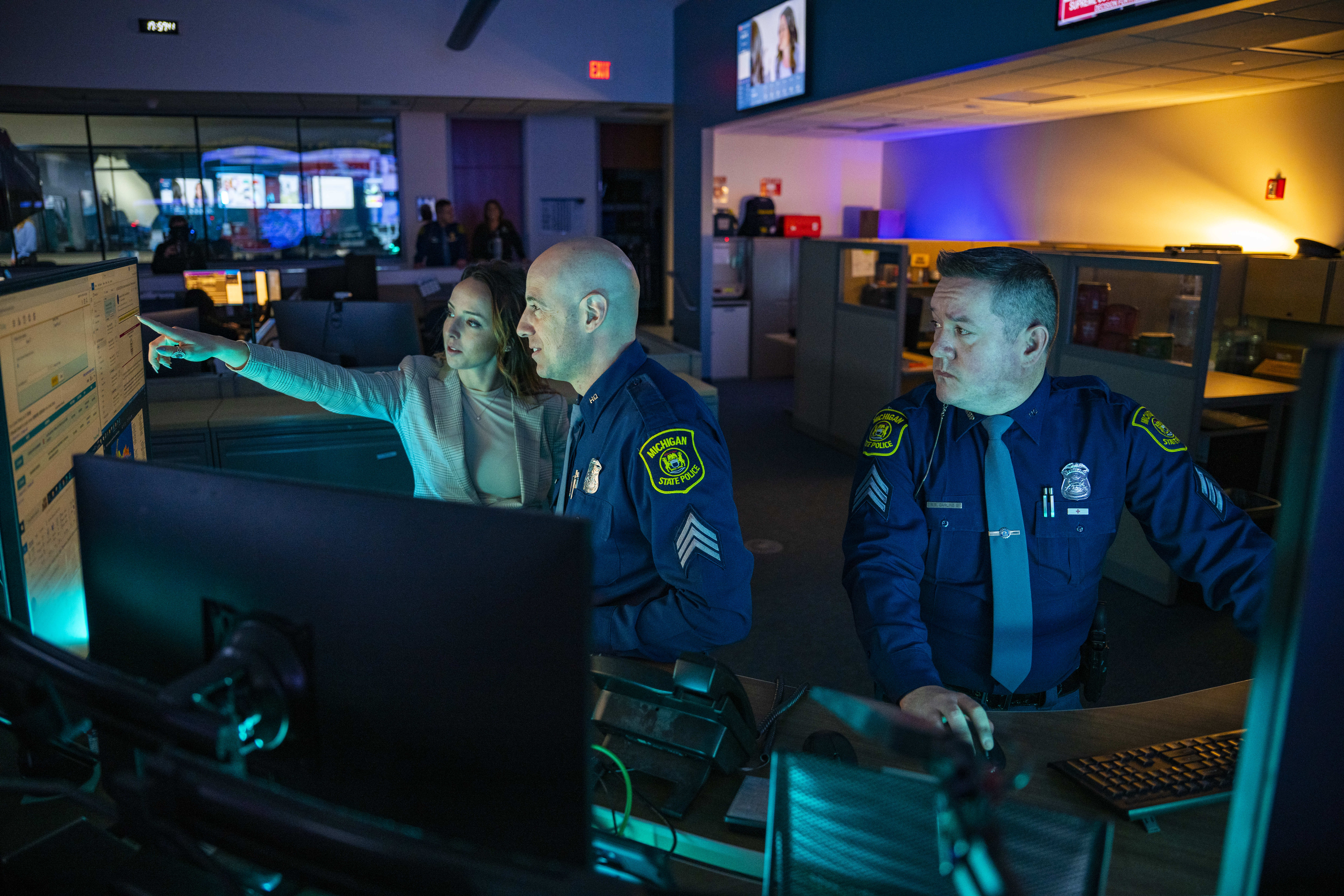 A civilian and two uniformed sergeants work in the Intelligence Operations Center.