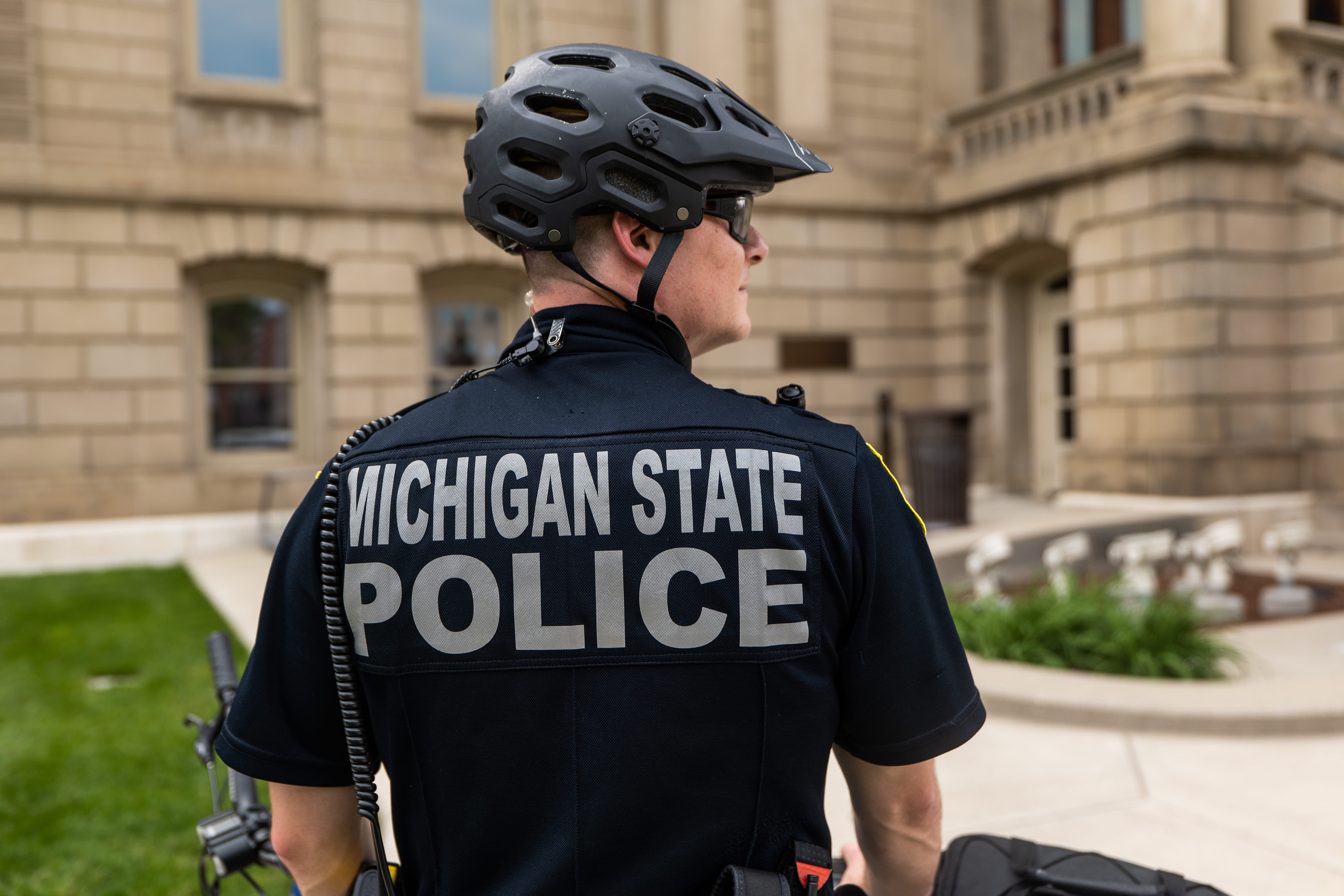 Michigan State Police State Properties Security Officer stands outside Capitol.