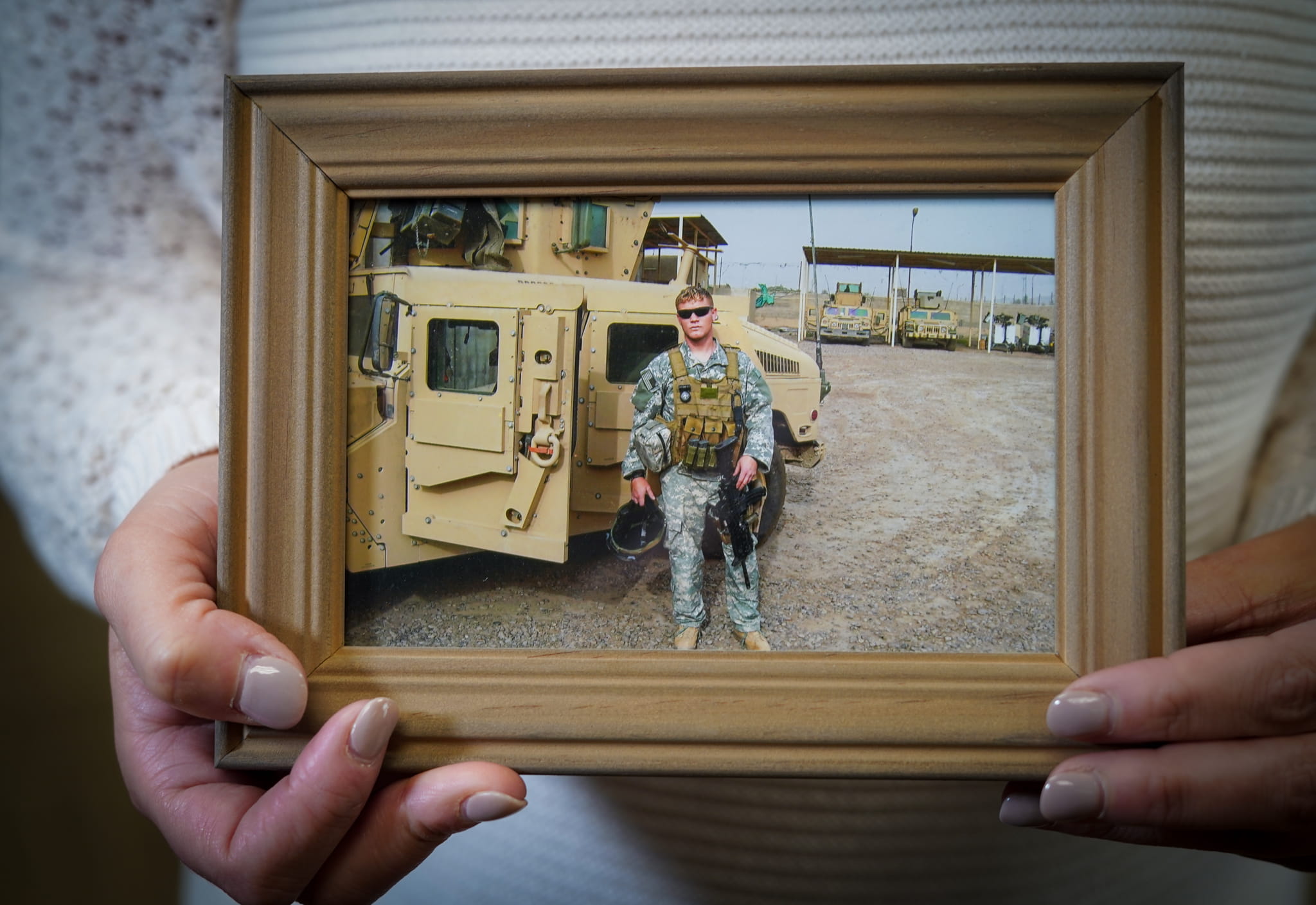 Kate Preston holding a photo of her late husband, Sgt. Darren Preston