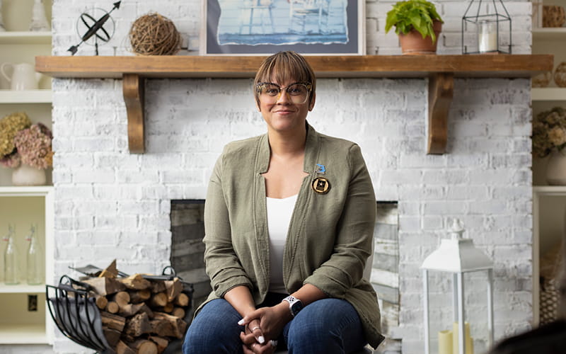 image of Lorrena Black seating in front of a fireplace