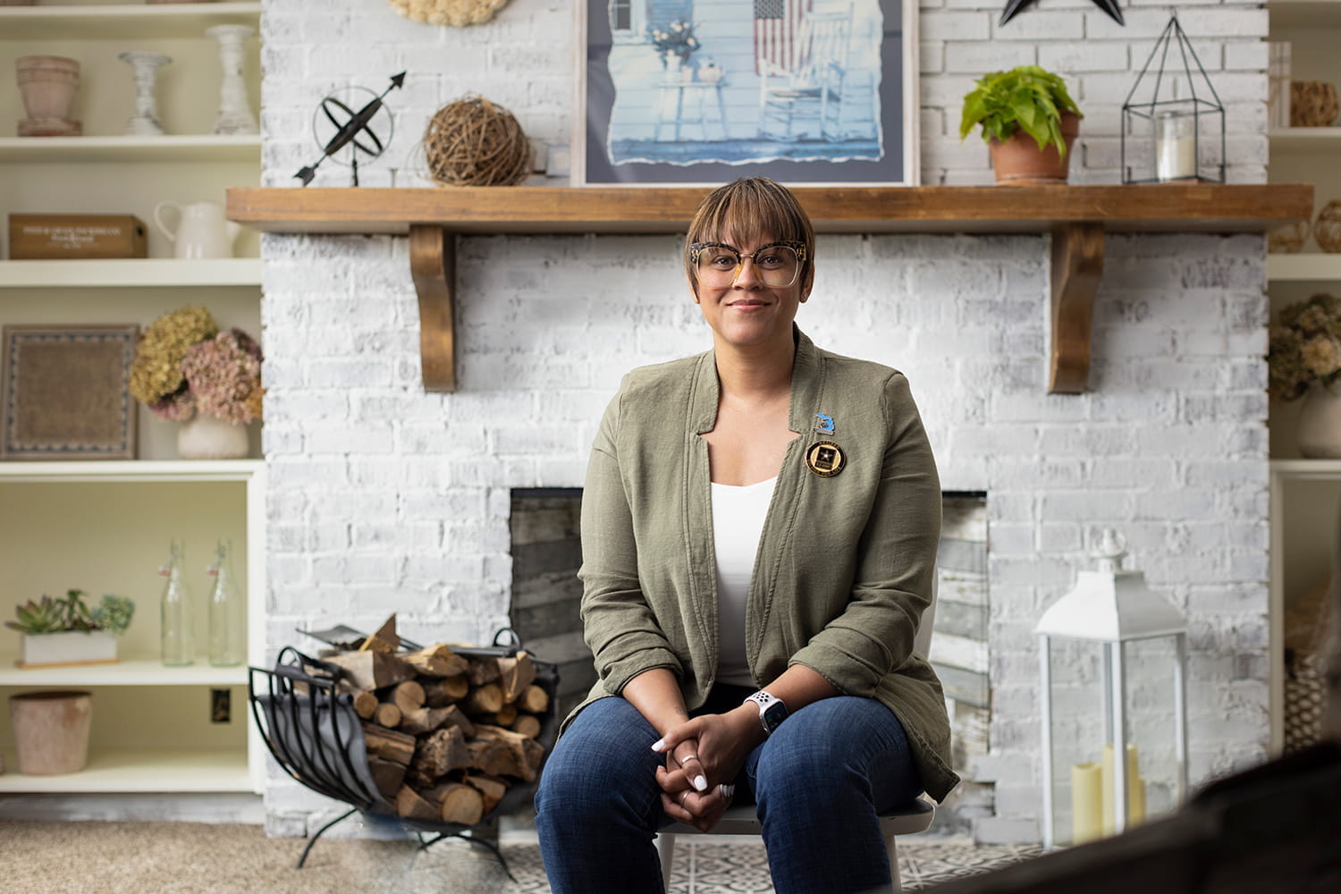 photo of Lorrena Black seated in front of a fireplace