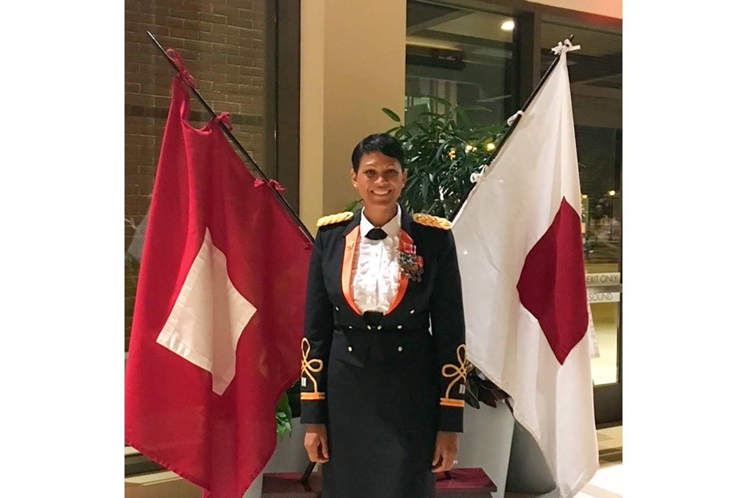 photo of Lorrena Black standing between 2 flags