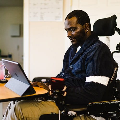 Man in wheelchair viewing e-reader