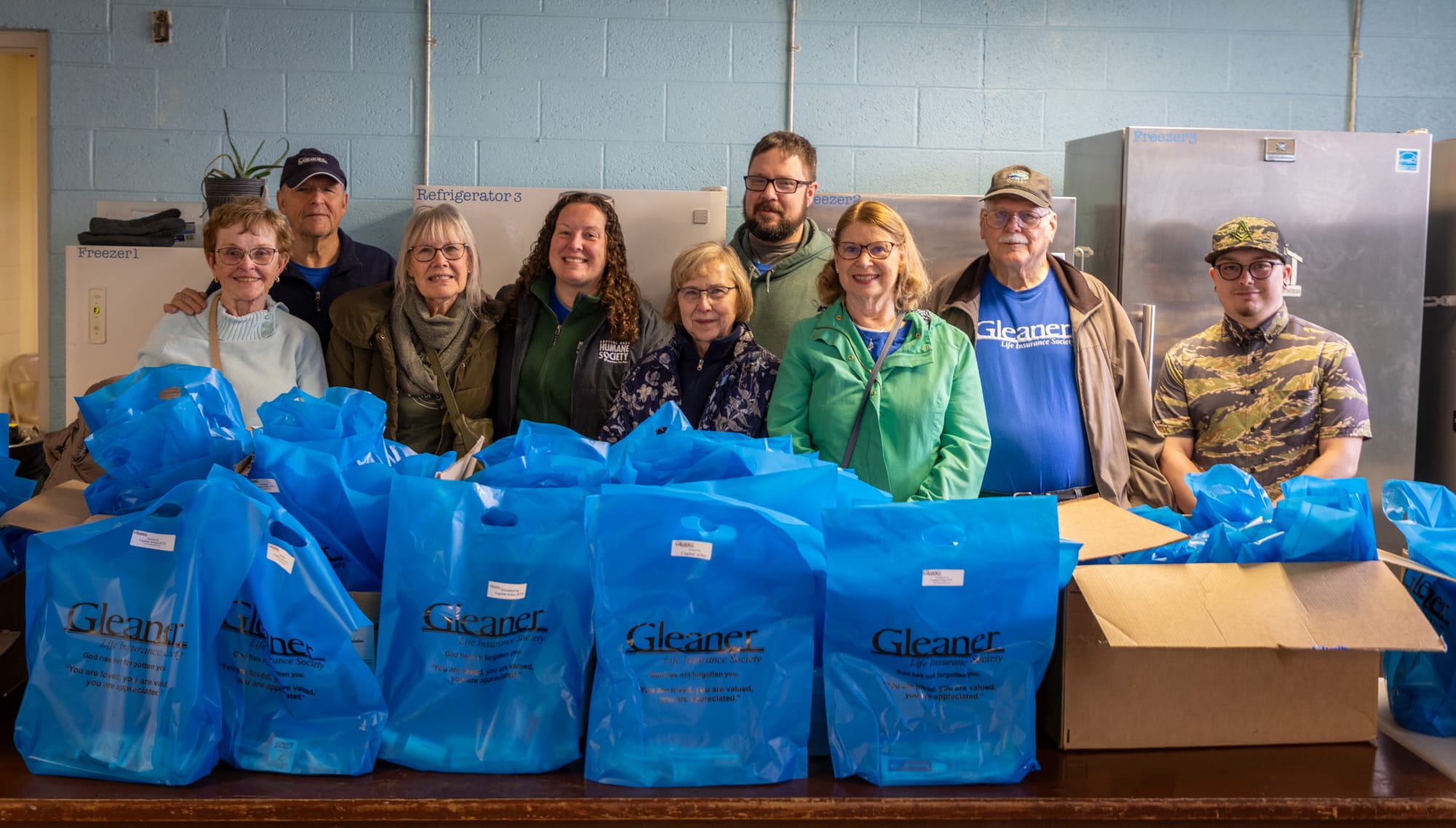 A group of nine volunteers with Capital Arbor pose with care kit bags