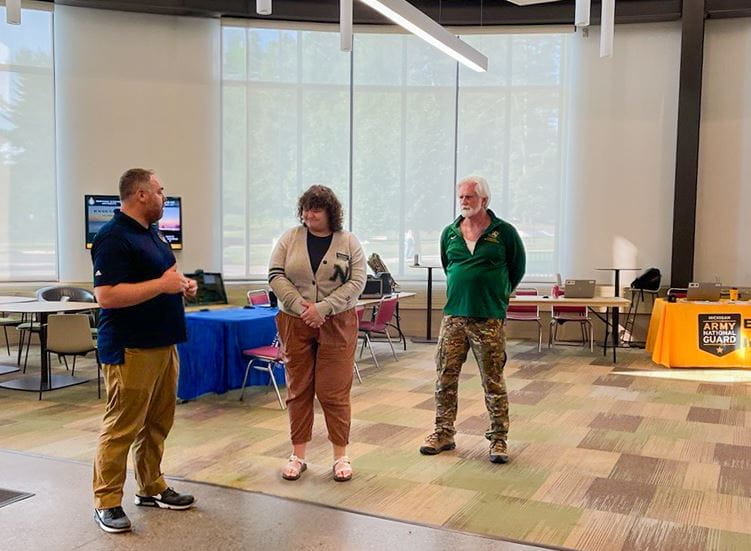 "Joe Saur, MVAA education analyst, presents the MVAA Coin of Excellence to Madi Spychalla, NMU Student Support Services Program assistant, with Mike Rutledge, NMU Veteran Services coordinator."