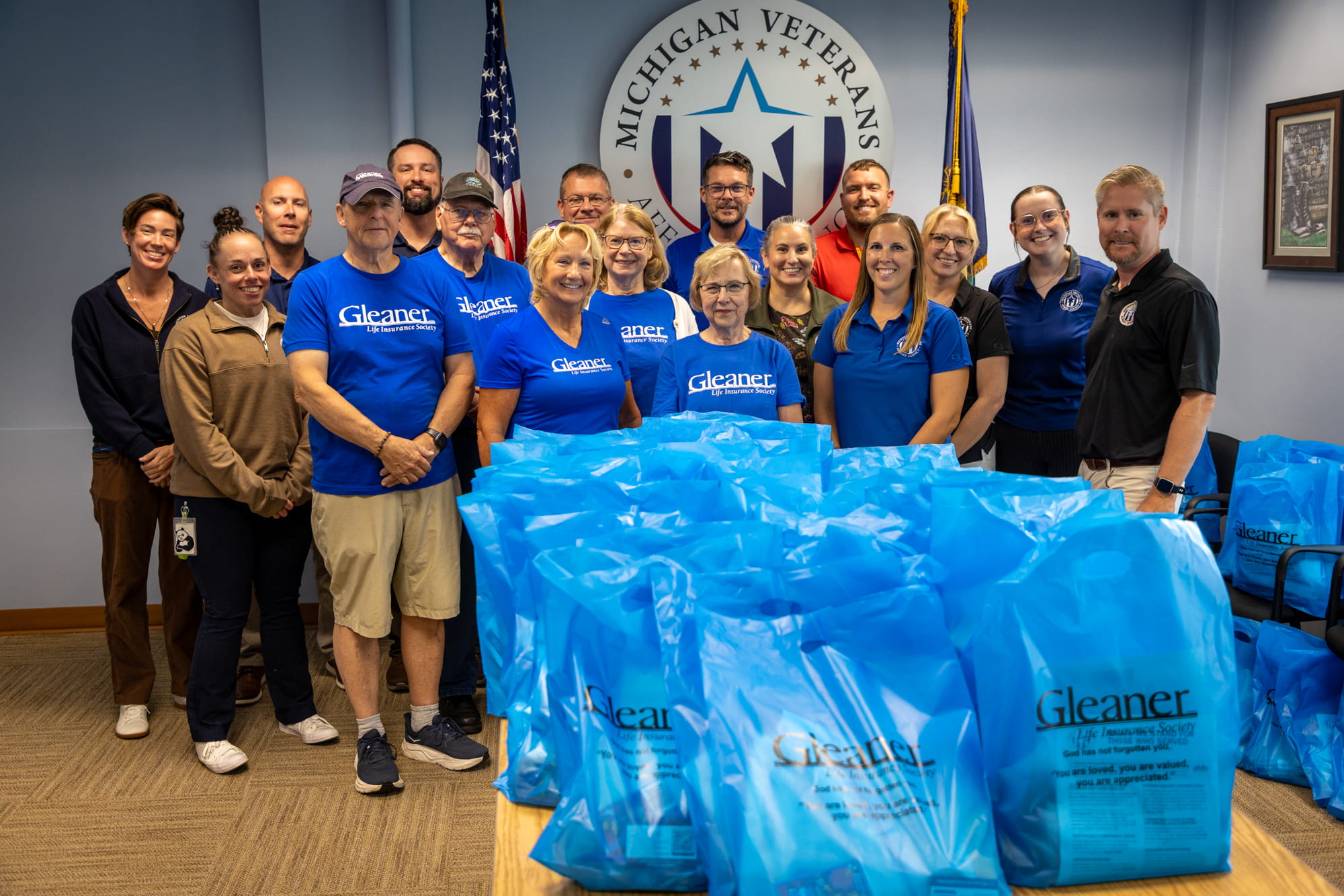 Volunteers posing for a picture in front of care kits for homeless veterans