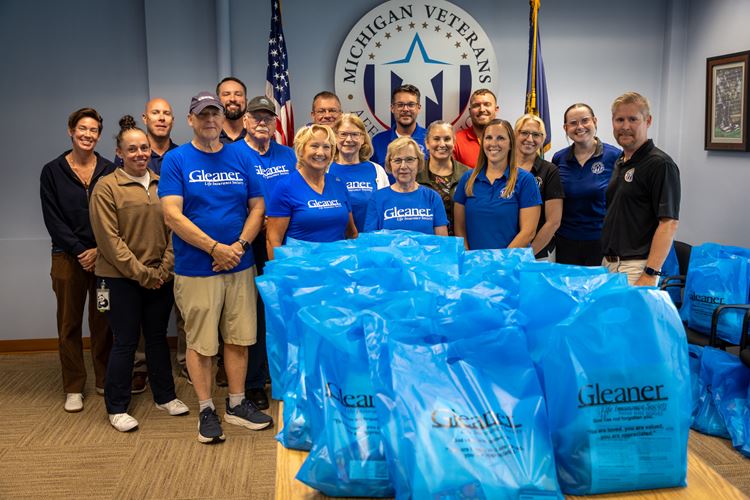 Volunteers posing for a picture in front of care kits for homeless veterans
