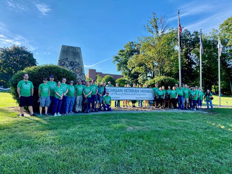 SpartanNash staff pose in front of Michigan Veteran Homes at Grand Rapids entrance sign