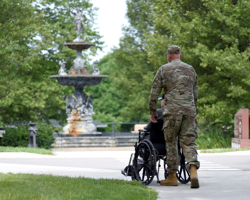 MING service member helping a veteran member outside.