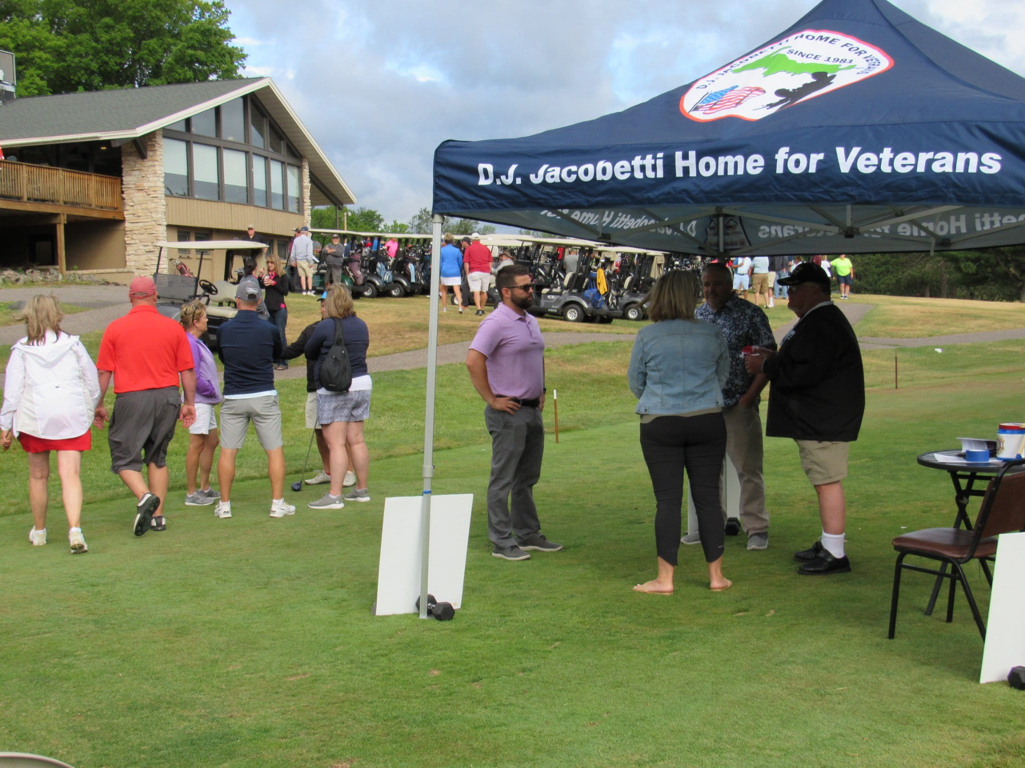 People standing around outside on a golf course preparing to play golf
