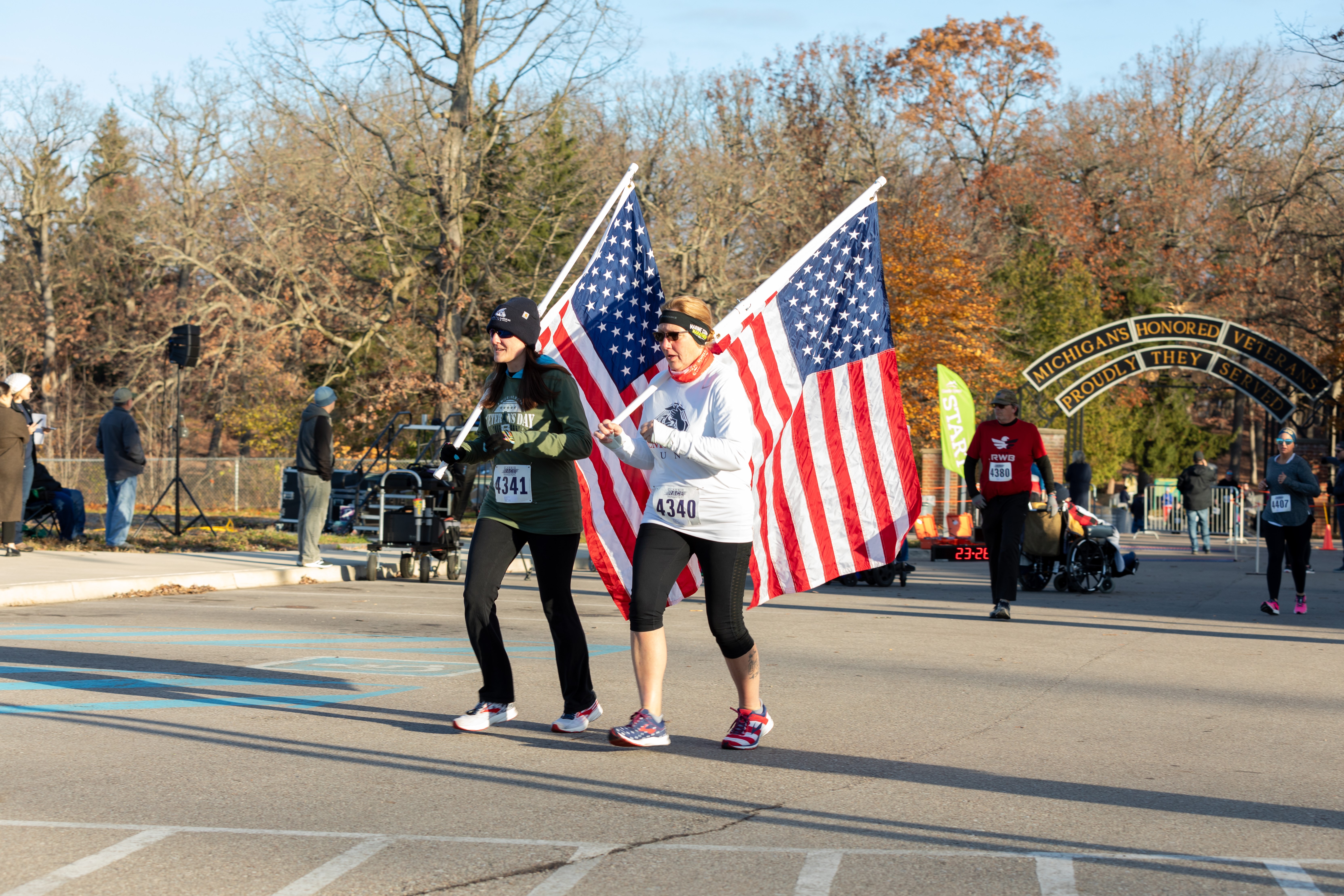 two runners carry the American flag
