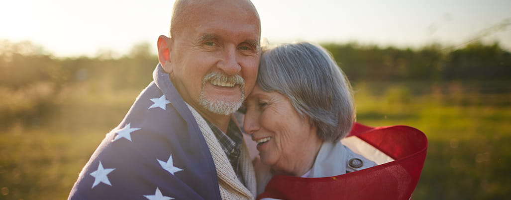 Veteran and partner shrouded by American Flag