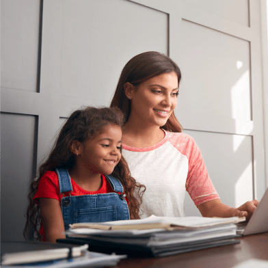 Photograph of a young girl watching her mother working on a laptop