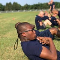 MYCA men doing sit ups outdoors on the grass