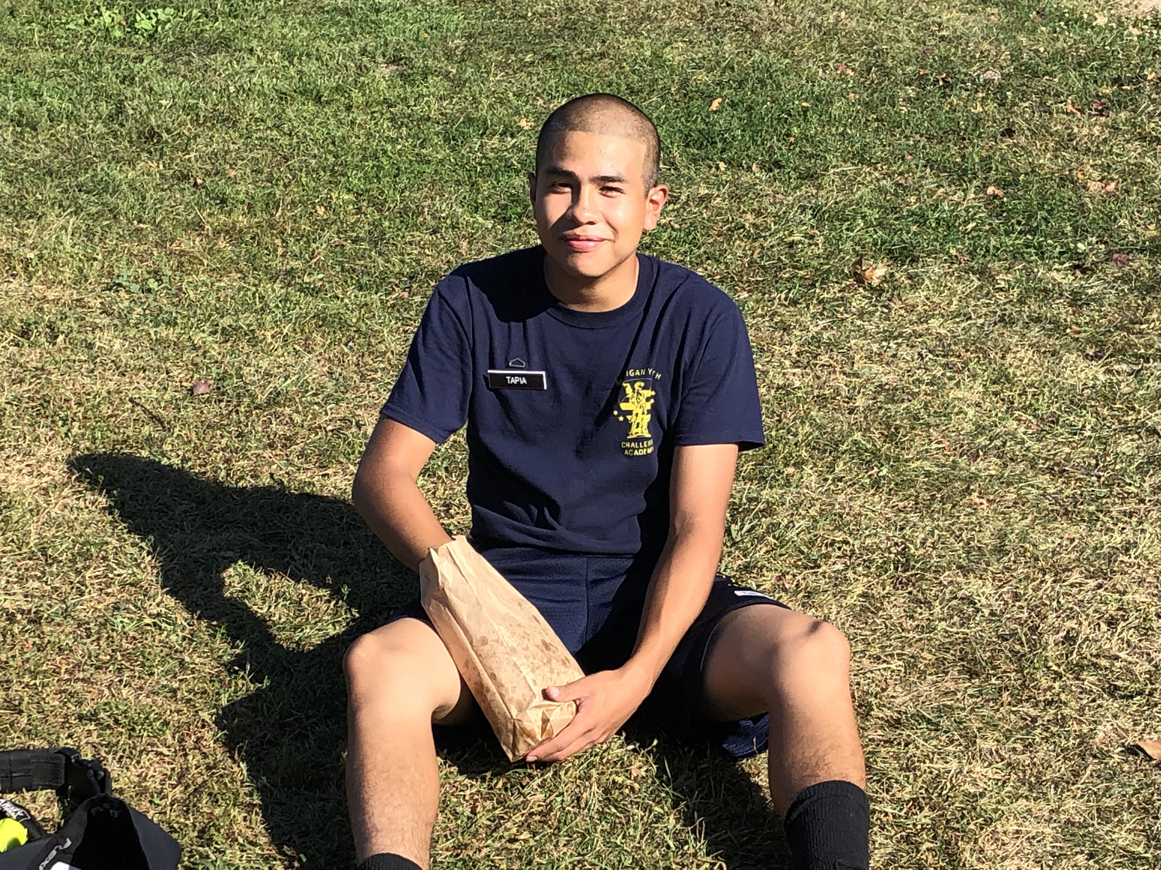 MYCA man sitting on grass smiling eating