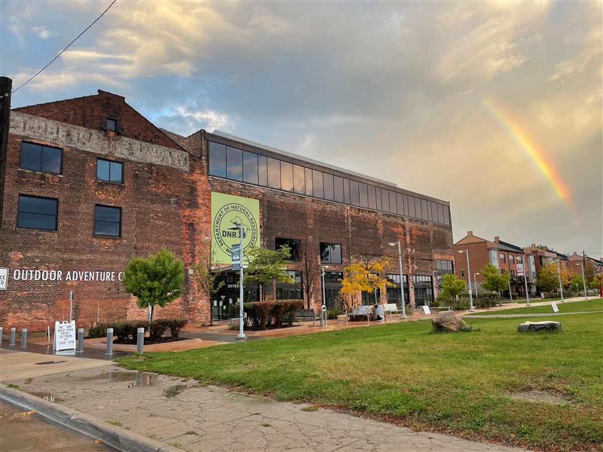 Outdoor Adventure Center building exterior with rainbow in sky