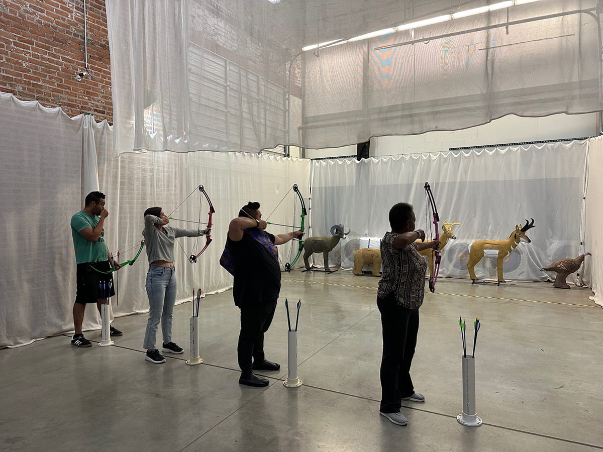 group of people shooting bows and arrows at animal decoy targets