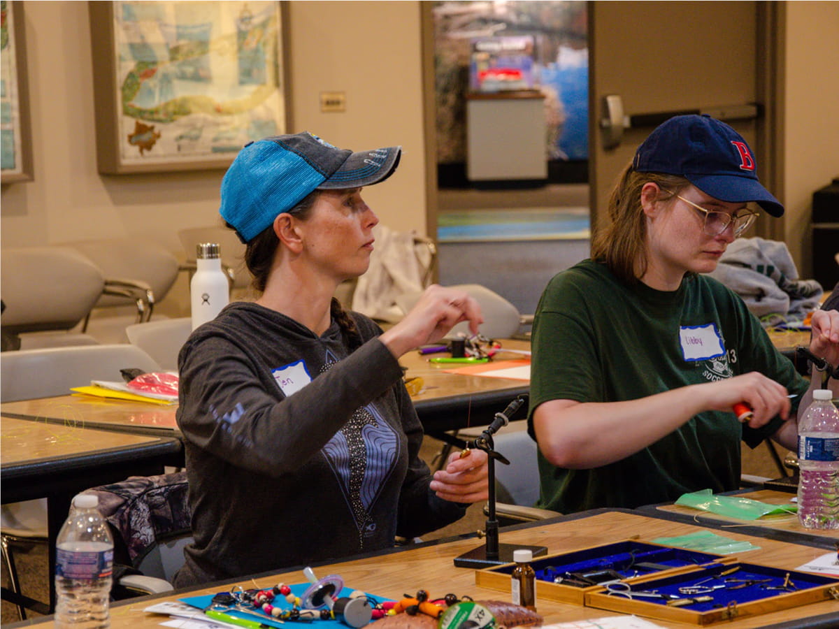 Two women tying flies during a class