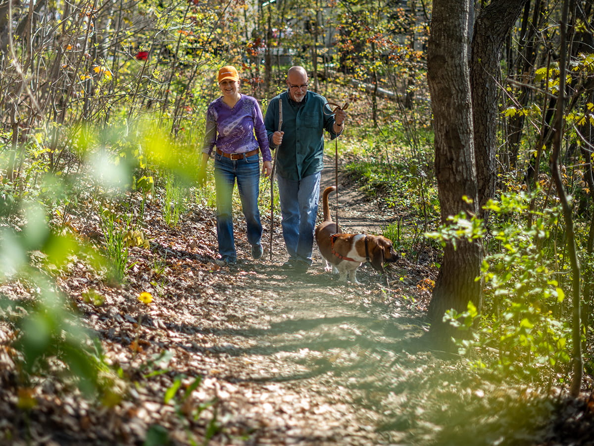 two people hiking on a wooded trail