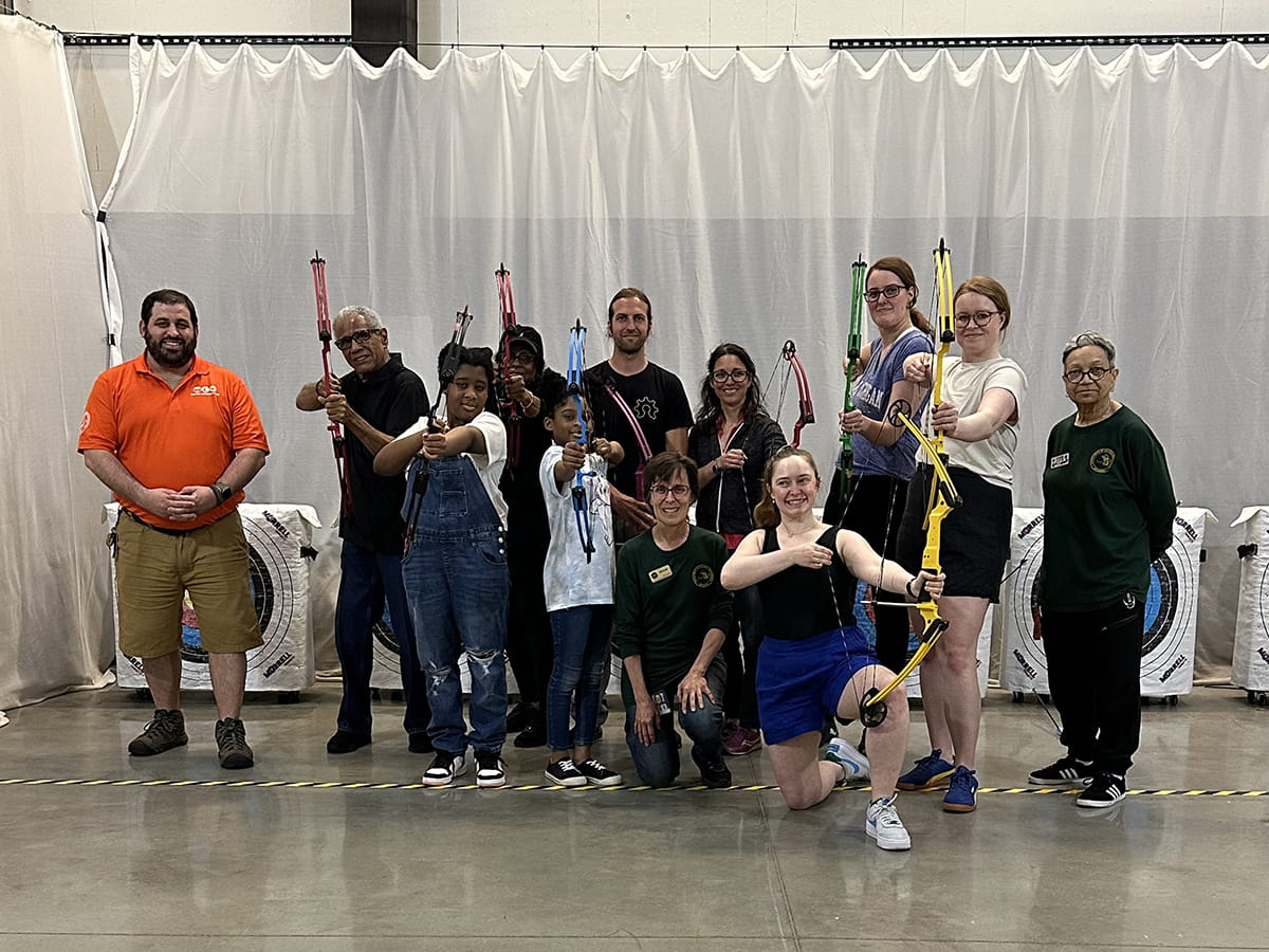 group photo of archery students with bows