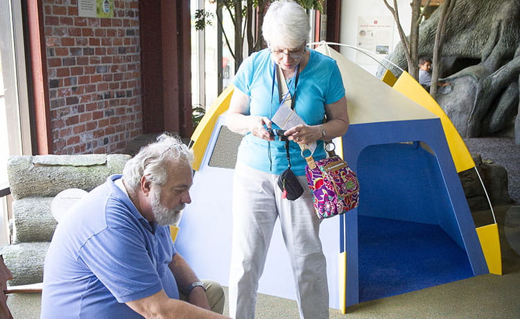 An adult couple exploring the camping exhibit