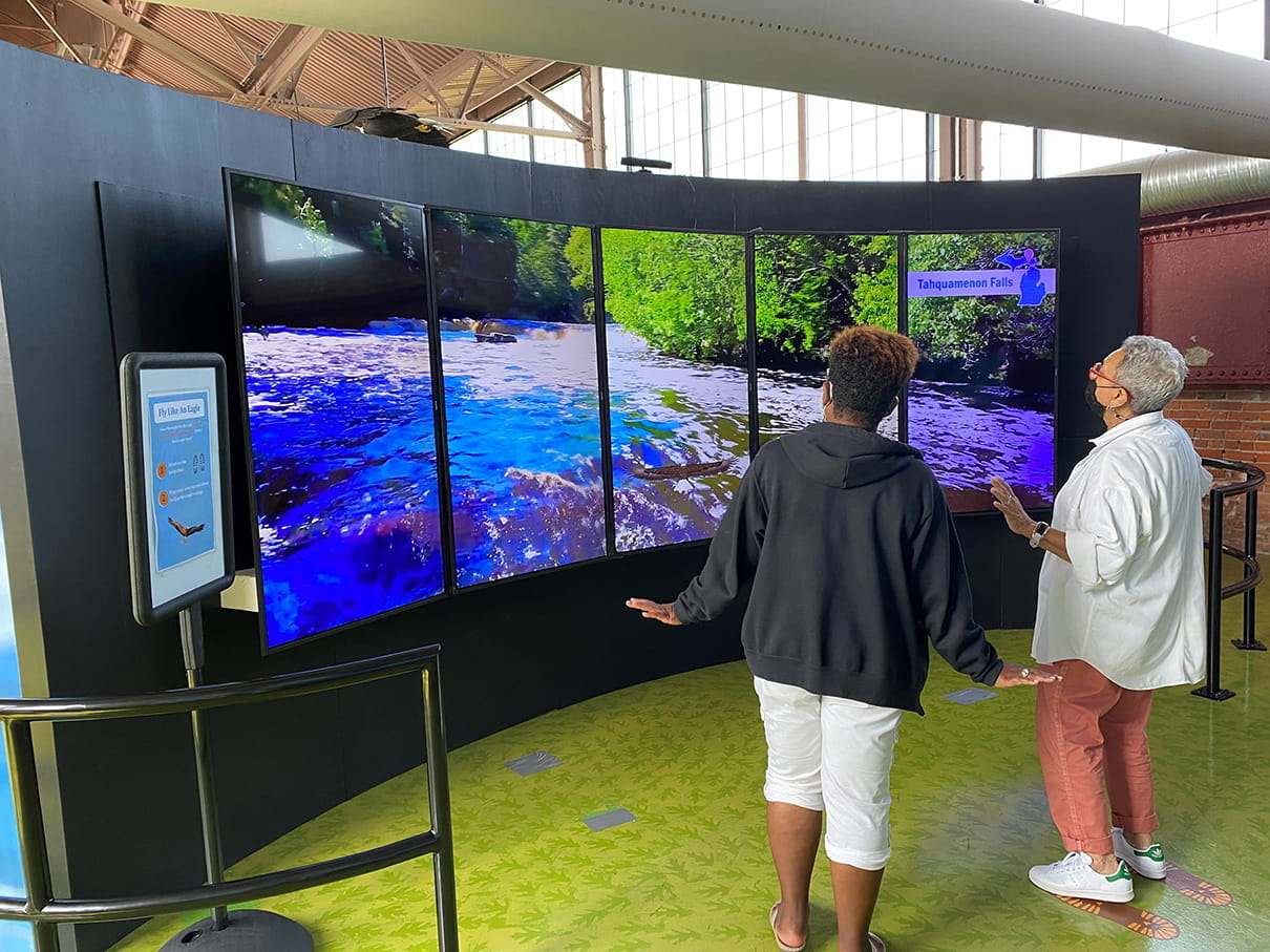 Women look at video screens in eagle exhibit at Outdoor Adventure Center