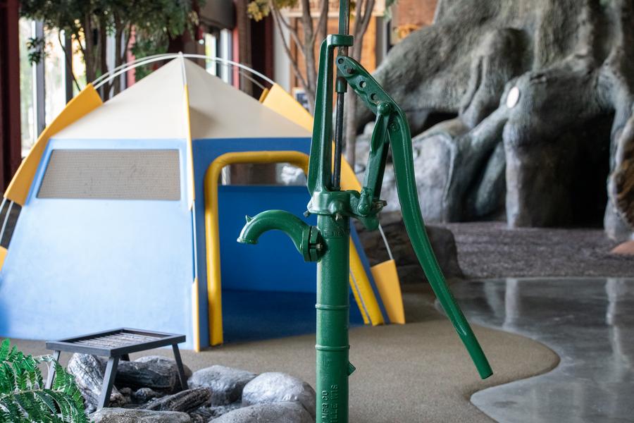 hand pump and tent in OAC campsite exhibit